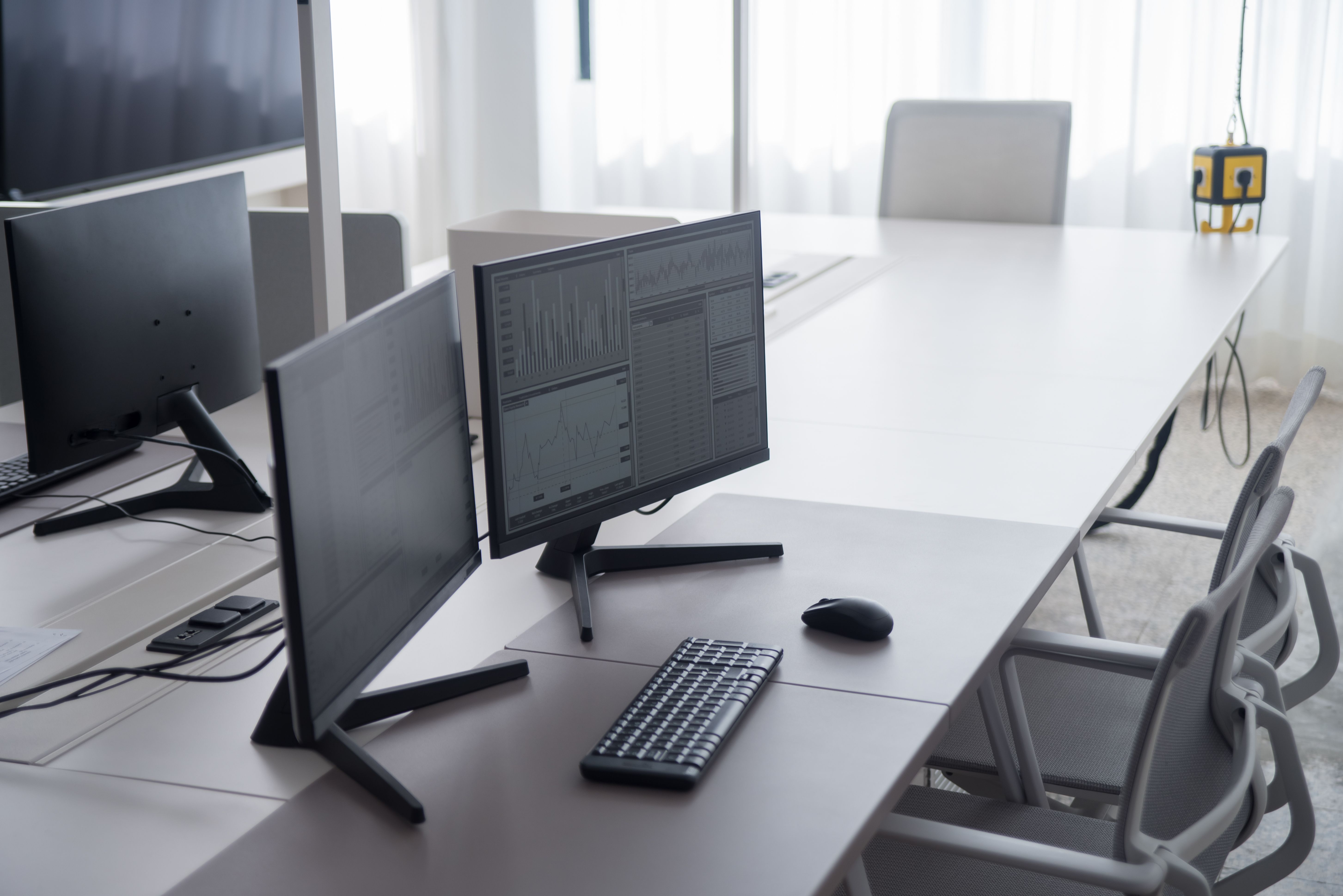 A desk with design work on screen and a phone showing a simple stage list.